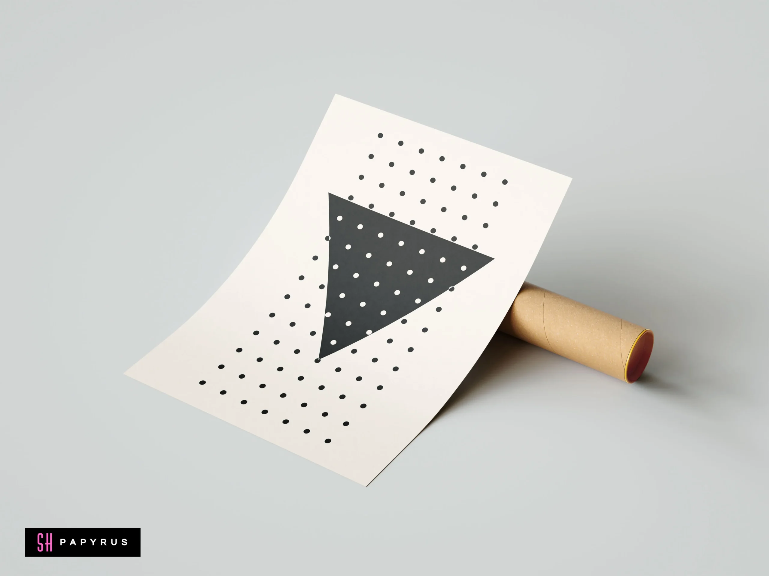 Minimalist black geometric triangle wall art print with polka dots on white background, leaning against a cardboard mailing tube.
